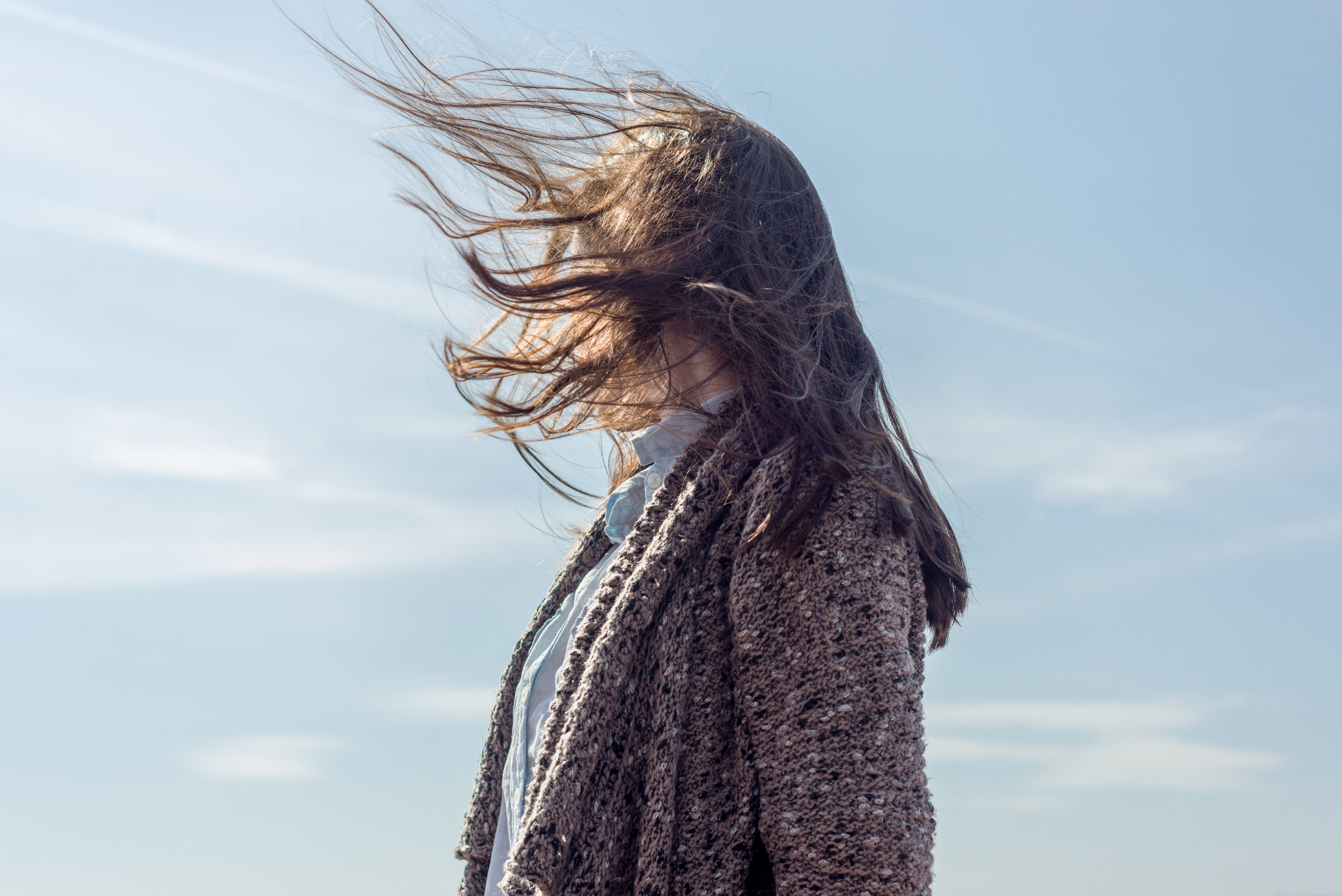 Vrouw met haren voor gezicht door harde wind